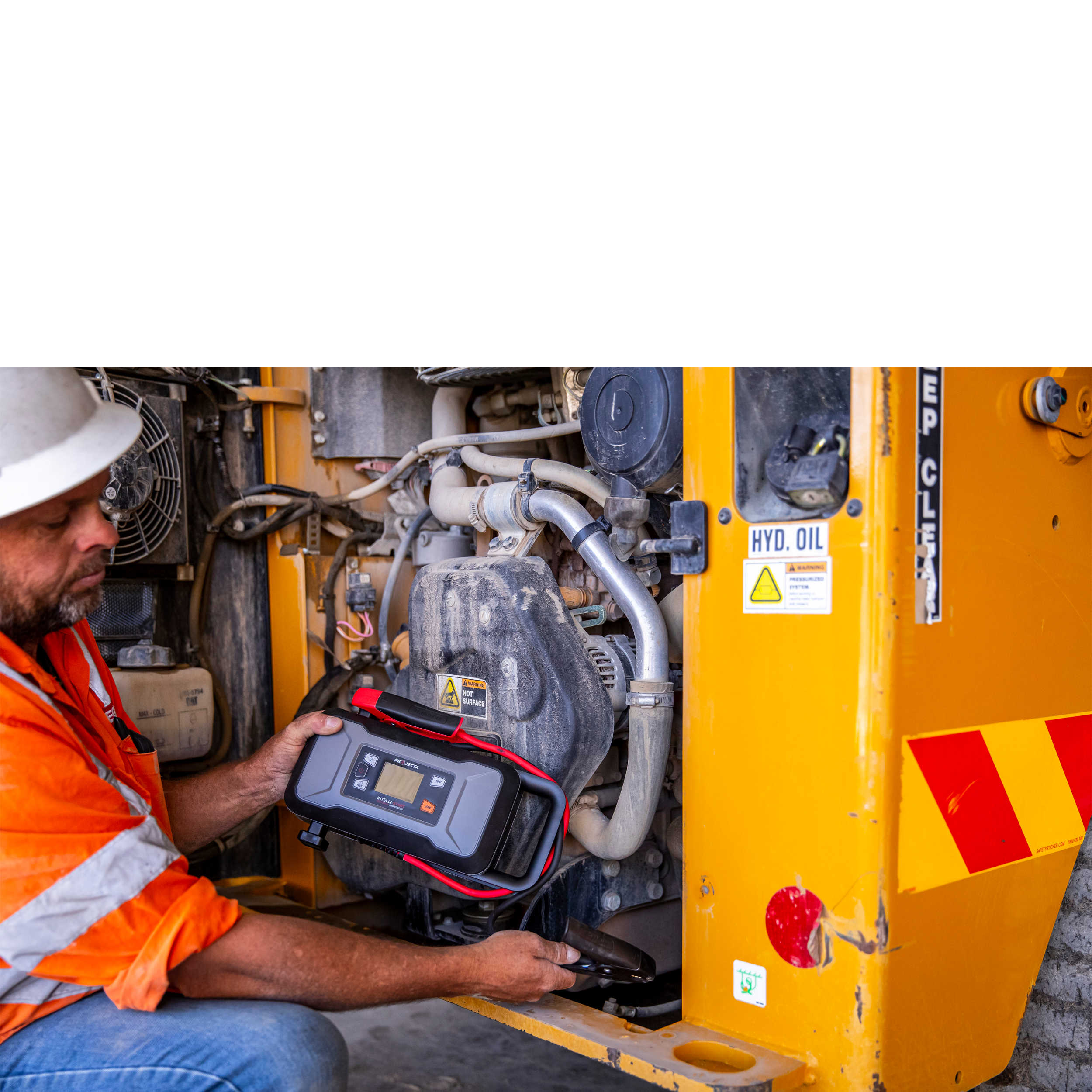 Person using a diagnostic tool on a yellow industrial machine